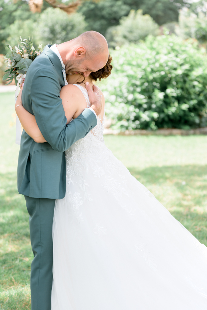 Photographie du mariage d'un couple de mariés enlacés et ssous l'émotion au domaine de la vallée aux pages. Photographe Patrick PIERRE